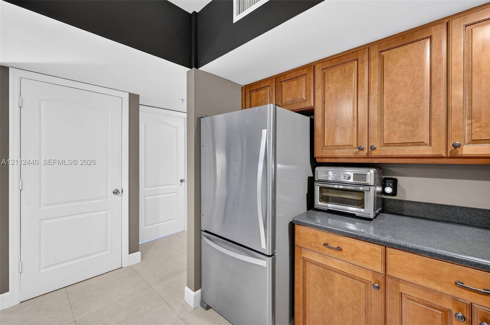 110 N Federal Highway, #914, Fort Lauderdale, FL 33301 Kitchen featuring wood cabinets, stainless refrigerator, dark countertops, porcelain flooring