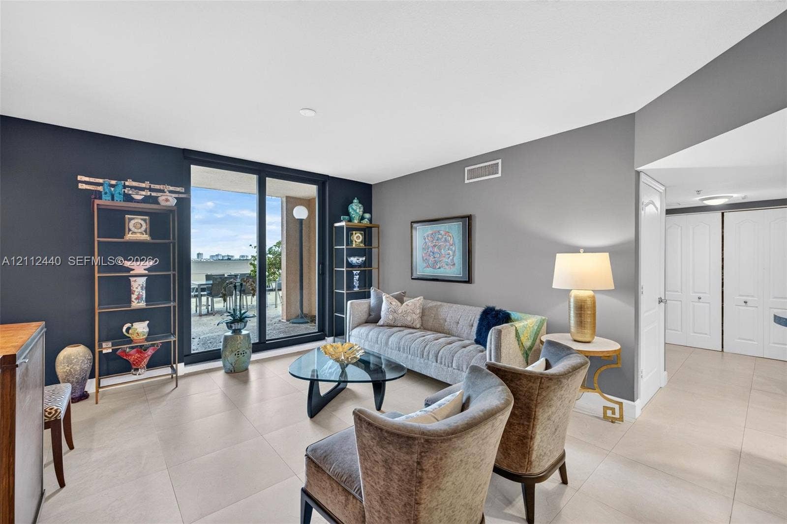 110 N Federal Highway, #914, Fort Lauderdale, FL 33301 Living space featuring large-format neutral porcelain tile, dual-tone painted walls, and sliding glass doors opening to an oversized exterior balcony