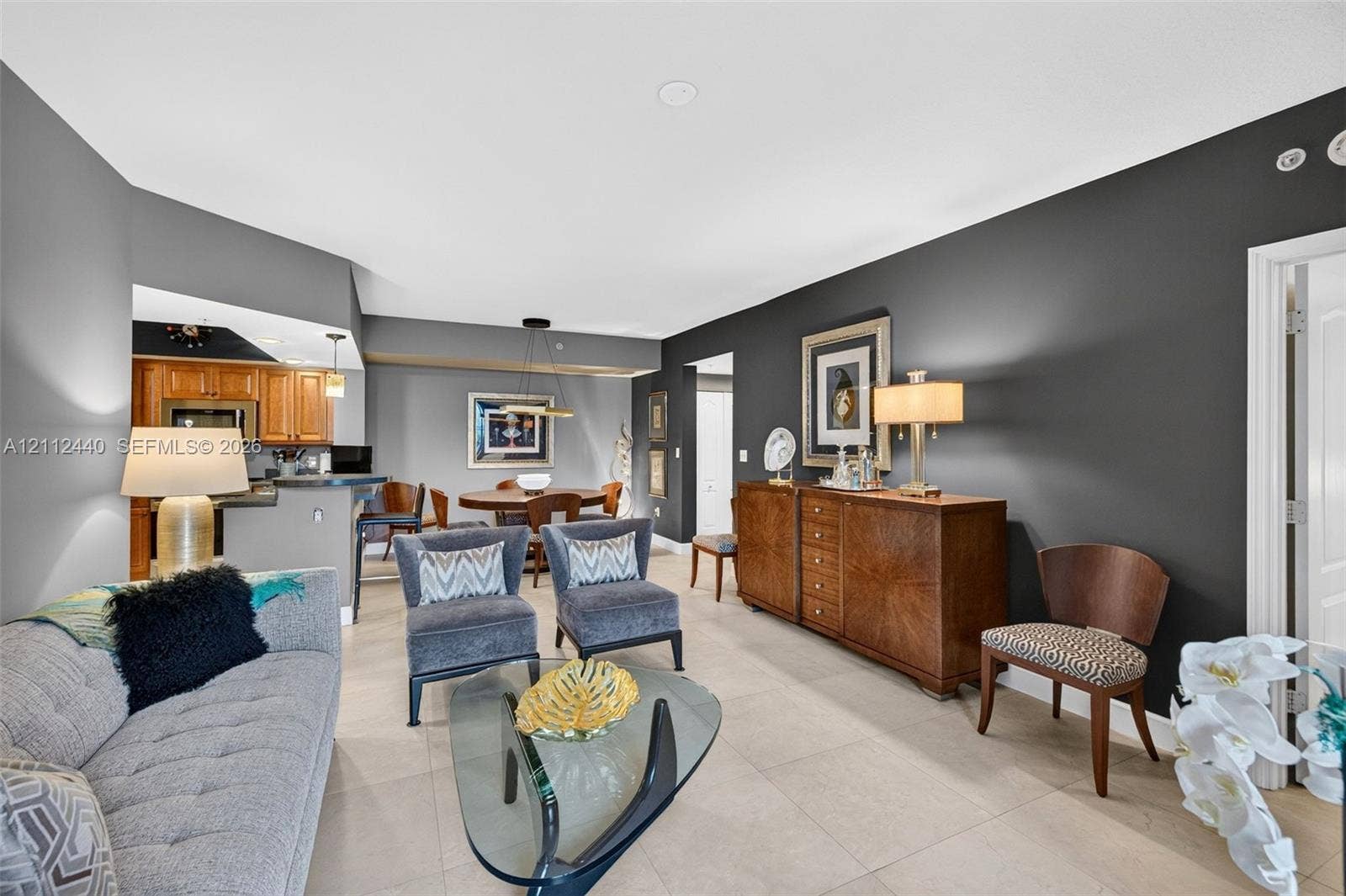 110 N Federal Highway, #914, Fort Lauderdale, FL 33301 Open-concept interior featuring large-format porcelain flooring, accent wall, and built-in kitchen cabinetry with breakfast bar
