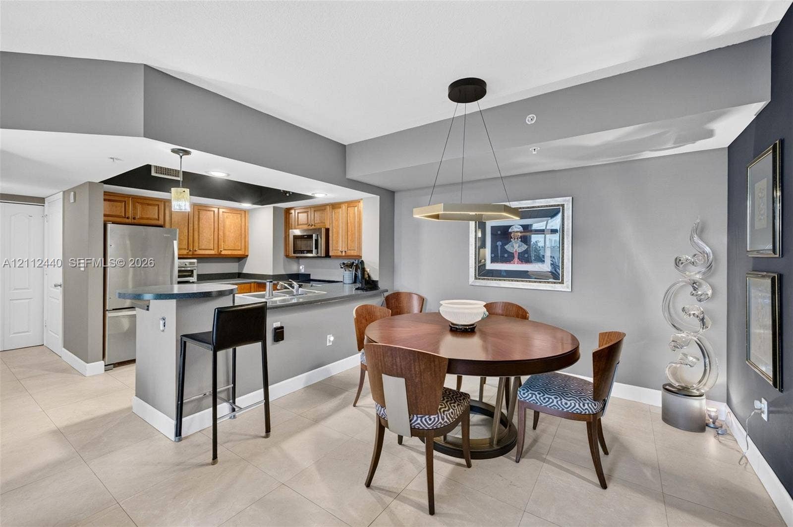 110 N Federal Highway, #914, Fort Lauderdale, FL 33301 Kitchen featuring upgraded wood cabinets, stainless appliances, and a breakfast bar, complemented by large-format porcelain flooring (dining fixture does not convey)