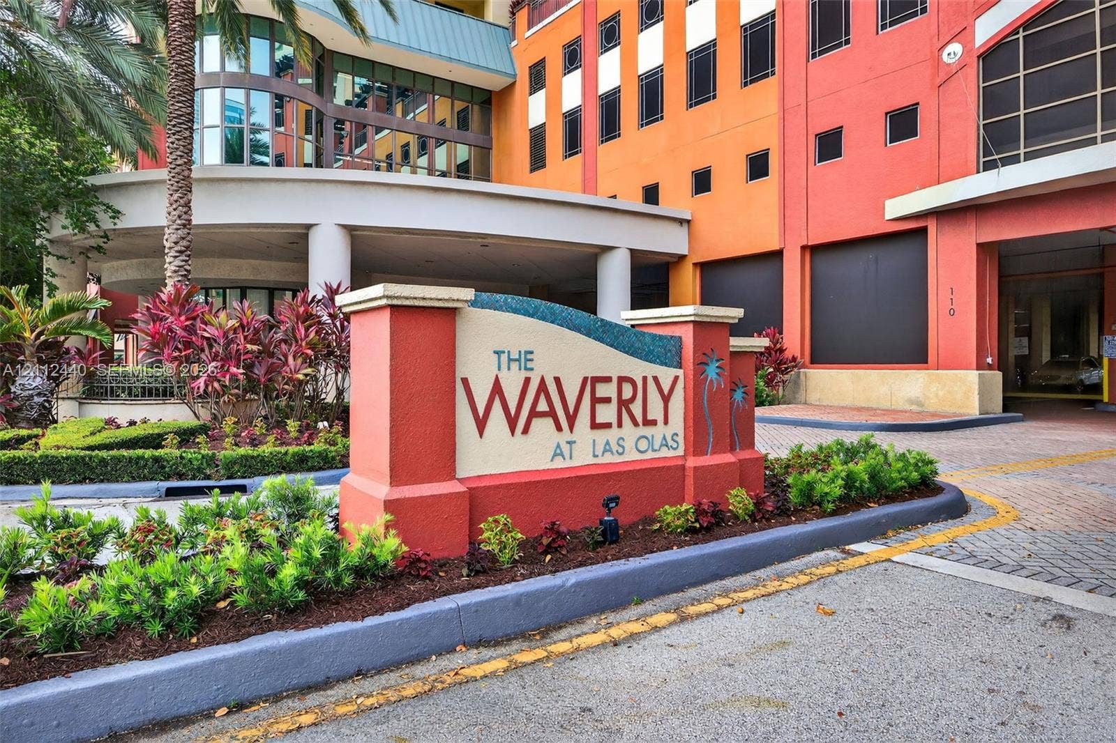 110 N Federal Highway, #914, Fort Lauderdale, FL 33301 Entrance sign with masonry construction, multi-story facade featuring textured exterior panels, covered arrival area, paver stone driveway, and curated landscaping