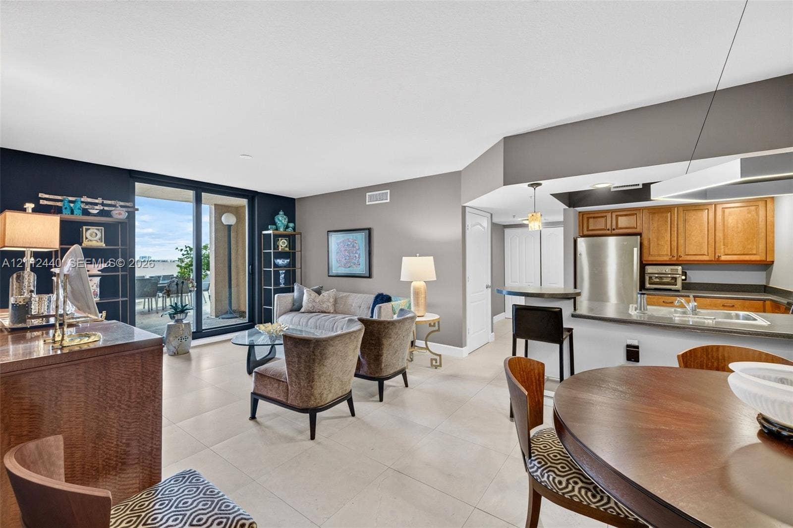 110 N Federal Highway, #914, Fort Lauderdale, FL 33301 Open-concept living space featuring large-format porcelain flooring, updated stainless appliances & wood cabinetry, a breakfast bar, and glass sliding doors lead to the HUGE terrace area