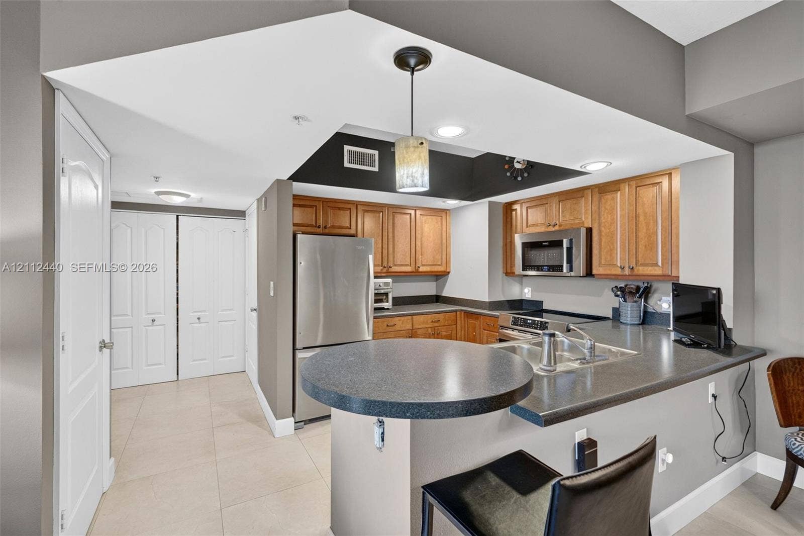 110 N Federal Highway, #914, Fort Lauderdale, FL 33301 Kitchen featuring wood cabinets, stainless appliances, a breakfast bar, and porcelain flooring
