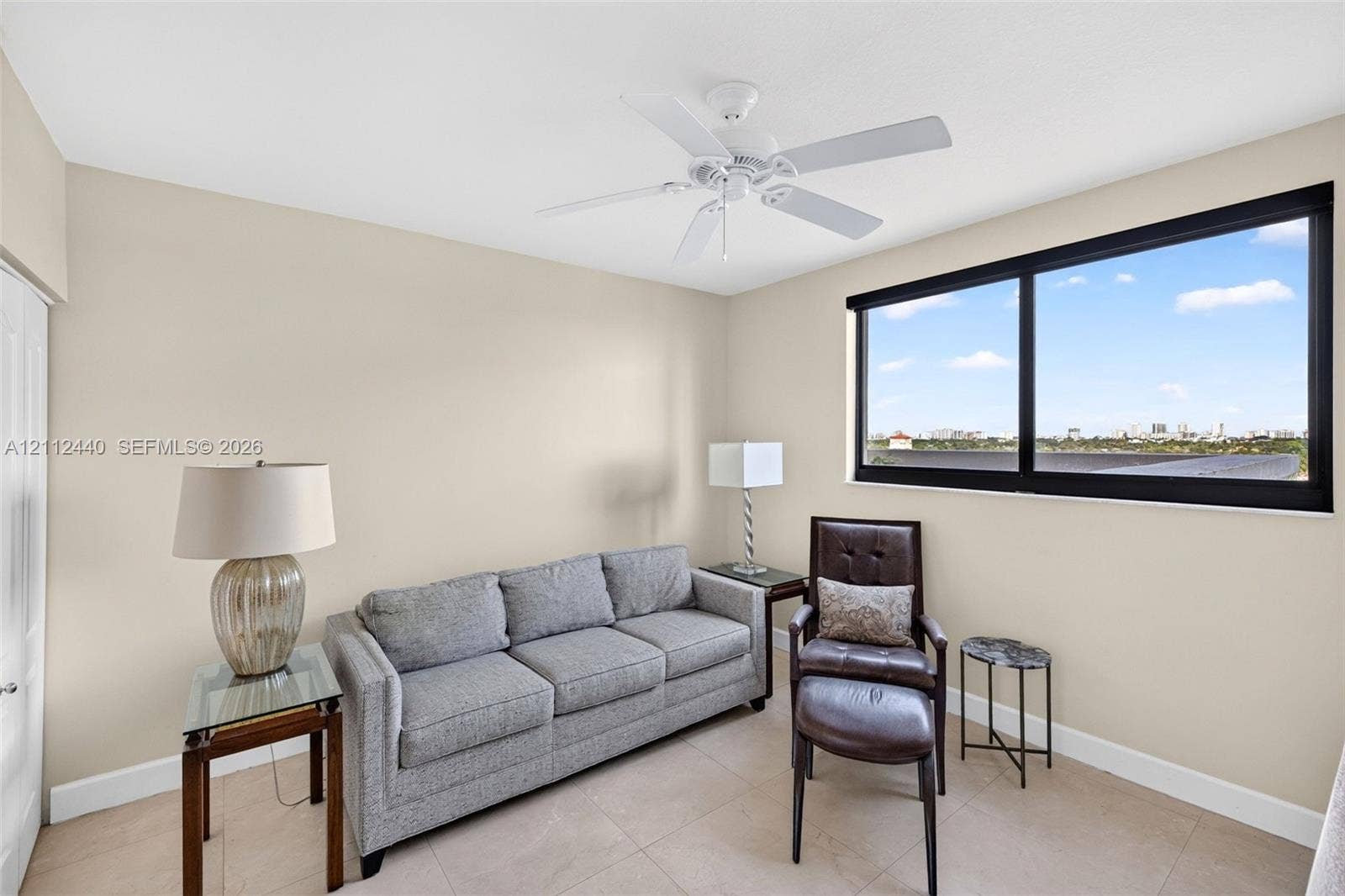 110 N Federal Highway, #914, Fort Lauderdale, FL 33301 Neutral interior walls, large black-framed picture window, tile flooring, and white ceiling fan with light fixture