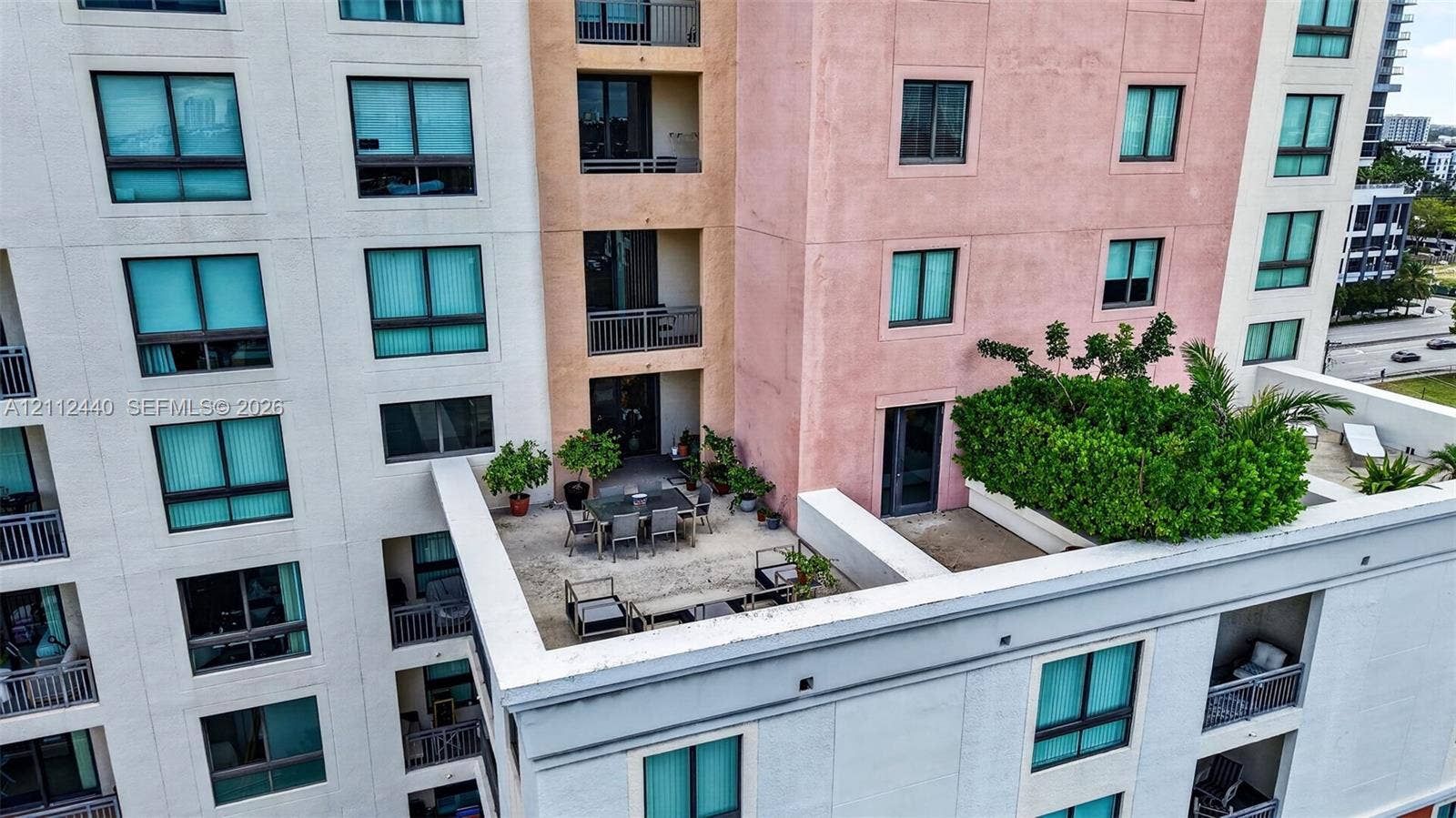 110 N Federal Highway, #914, Fort Lauderdale, FL 33301 High-rise exterior featuring multi-colored stucco facade, expansive concrete terrace, integrated privacy landscaping, and recessed private balconies