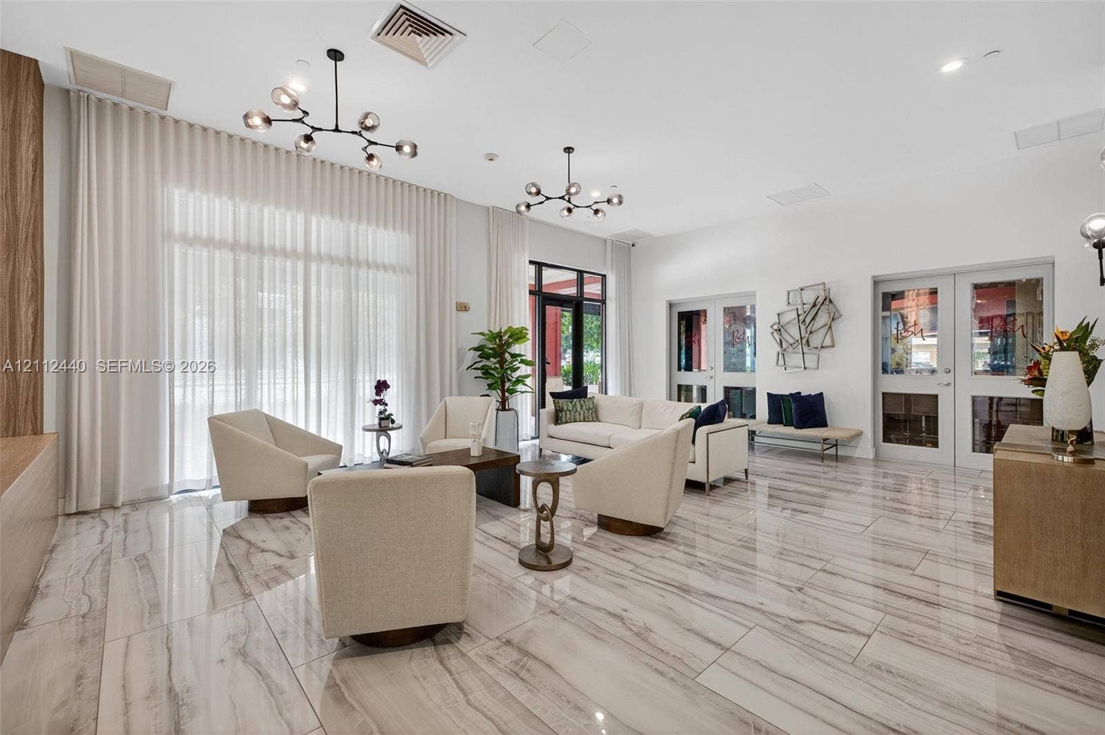 110 N Federal Highway, #914, Fort Lauderdale, FL 33301 Open-concept space featuring polished stone-finish flooring, floor-to-ceiling drapery, dual multi-arm sputnik-style chandeliers, and French doors lead to the restaurant / bar, Posh, right on the ground floor