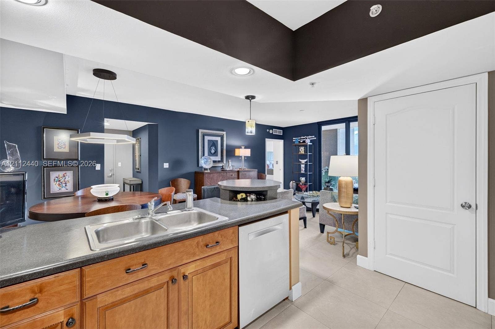 110 N Federal Highway, #914, Fort Lauderdale, FL 33301 Kitchen featuring solid wood cabinetry, dark countertops, a stainless double-basin sink, recessed lighting, and a neutral porcelain floor