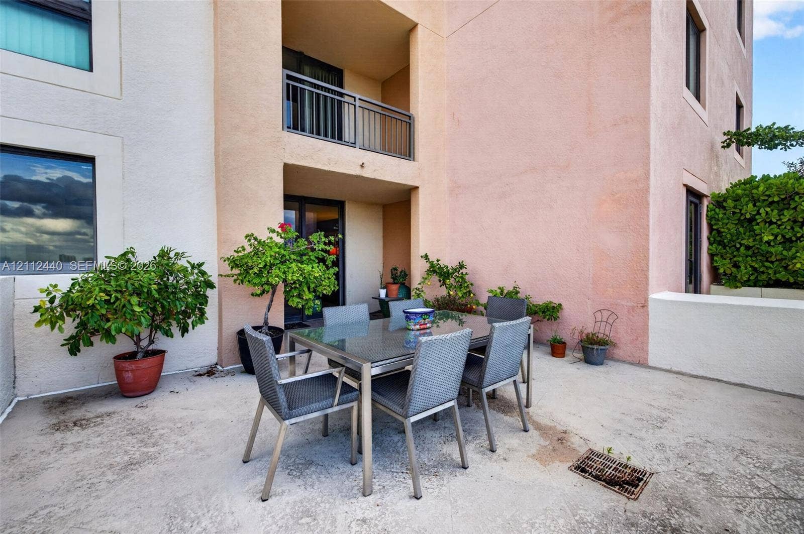 110 N Federal Highway, #914, Fort Lauderdale, FL 33301 Spacious concrete patio featuring a stucco exterior, a covered balcony with a metal railing, and low-rise wall enclosures