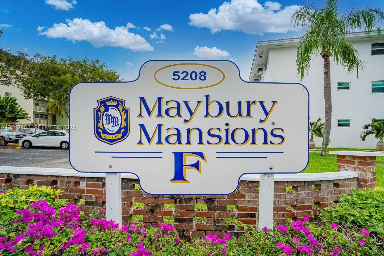 2455 NE 51st Street, #E114, Fort Lauderdale, FL 33308 Custom property signage for Maybury Mansions featuring a brick masonry wall and mature tropical landscaping