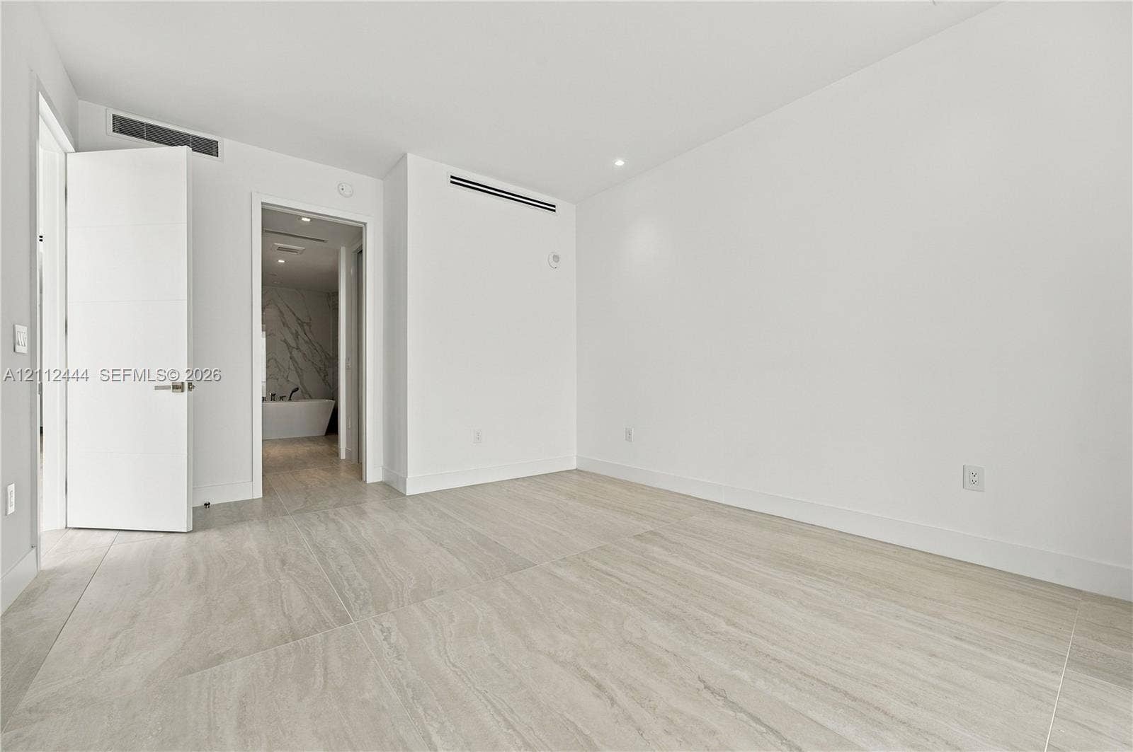 Large-format tile flooring, recessed ceiling lighting, and solid-core doors