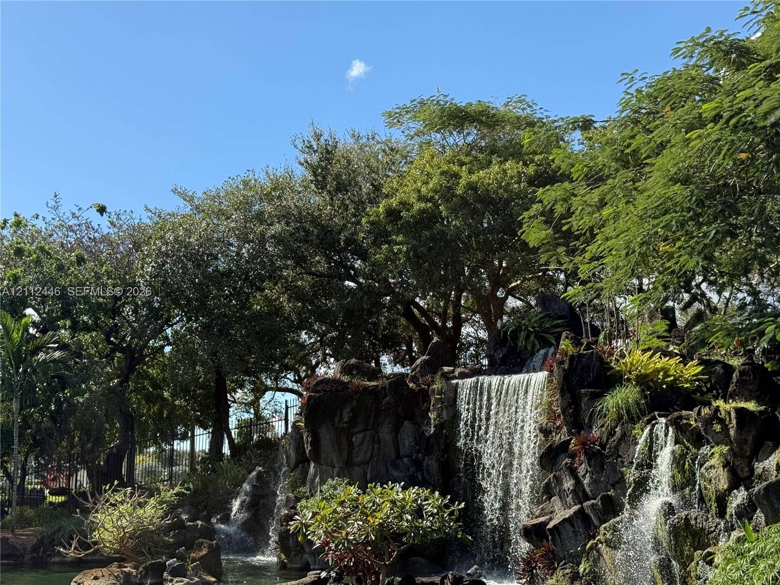 6100 S Falls Cir Drive, #411, Lauderhill, FL 33319 Multi-tiered stone waterfall feature with mature landscaping and established trees