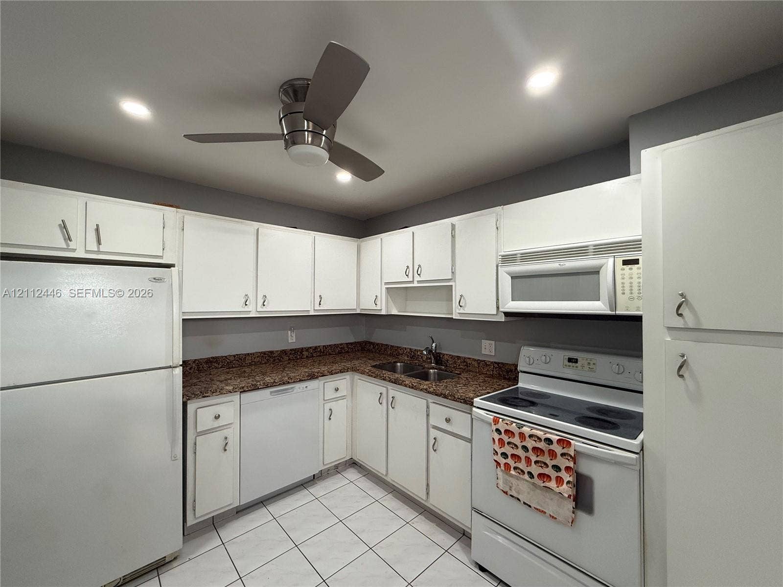 6100 S Falls Cir Drive, #411, Lauderhill, FL 33319 Kitchen featuring white cabinetry, speckled stone countertops, tiled flooring, recessed lighting, and a ceiling fan