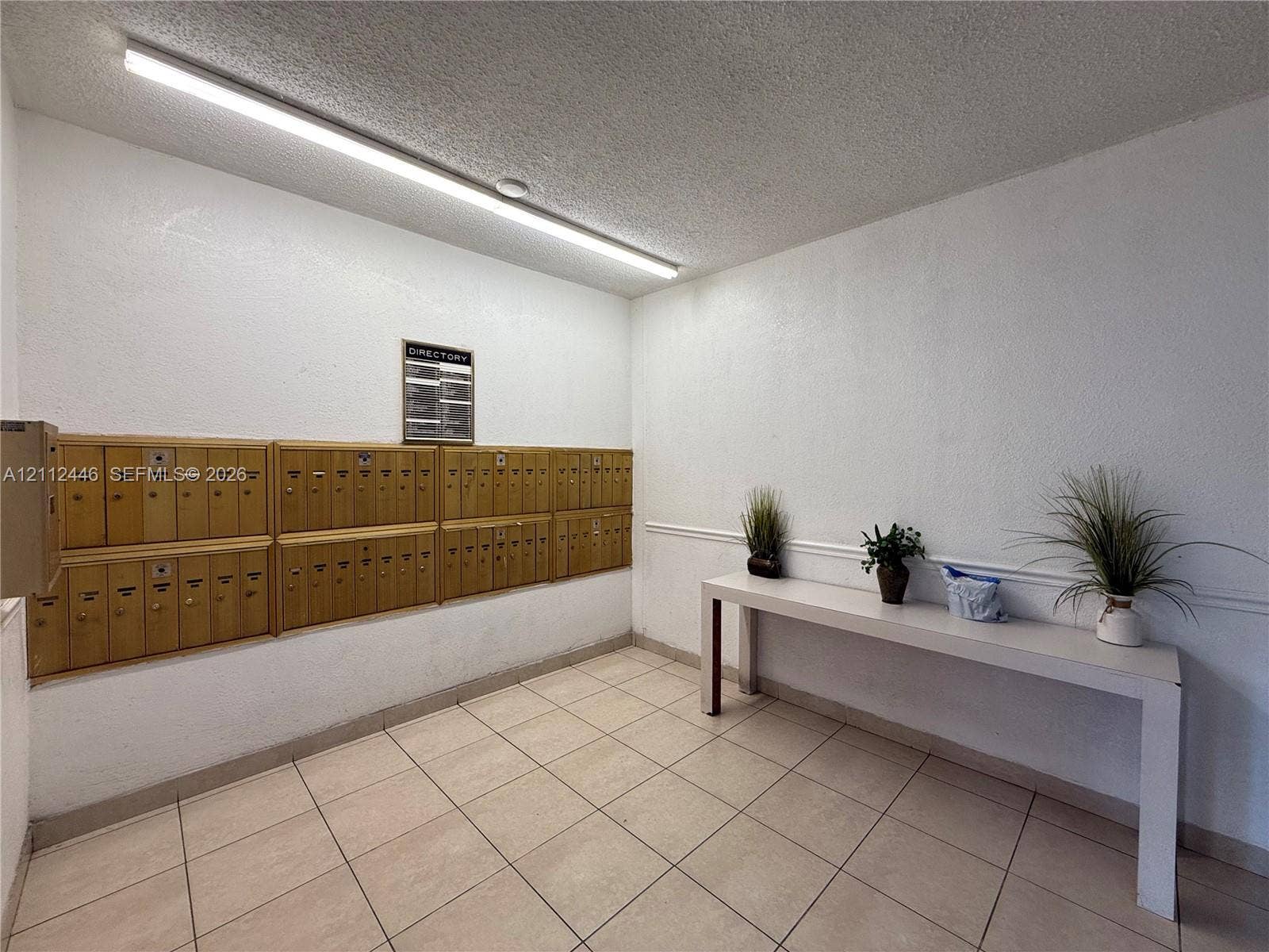 6100 S Falls Cir Drive, #411, Lauderhill, FL 33319 Wall-mounted metal mailboxes, linear ceiling-mounted lighting, and tile flooring