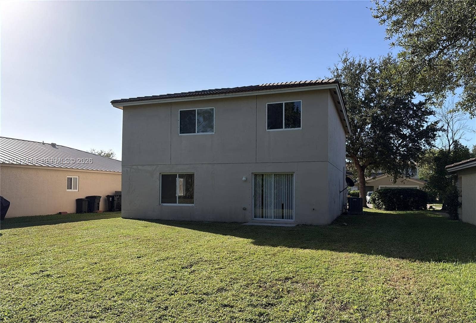 2007 SW Marblehead Way, Port St Lucie, FL 34953 Two-story exterior featuring a neutral stucco finish, a hip roof with tile shingles, and sliding glass patio doors