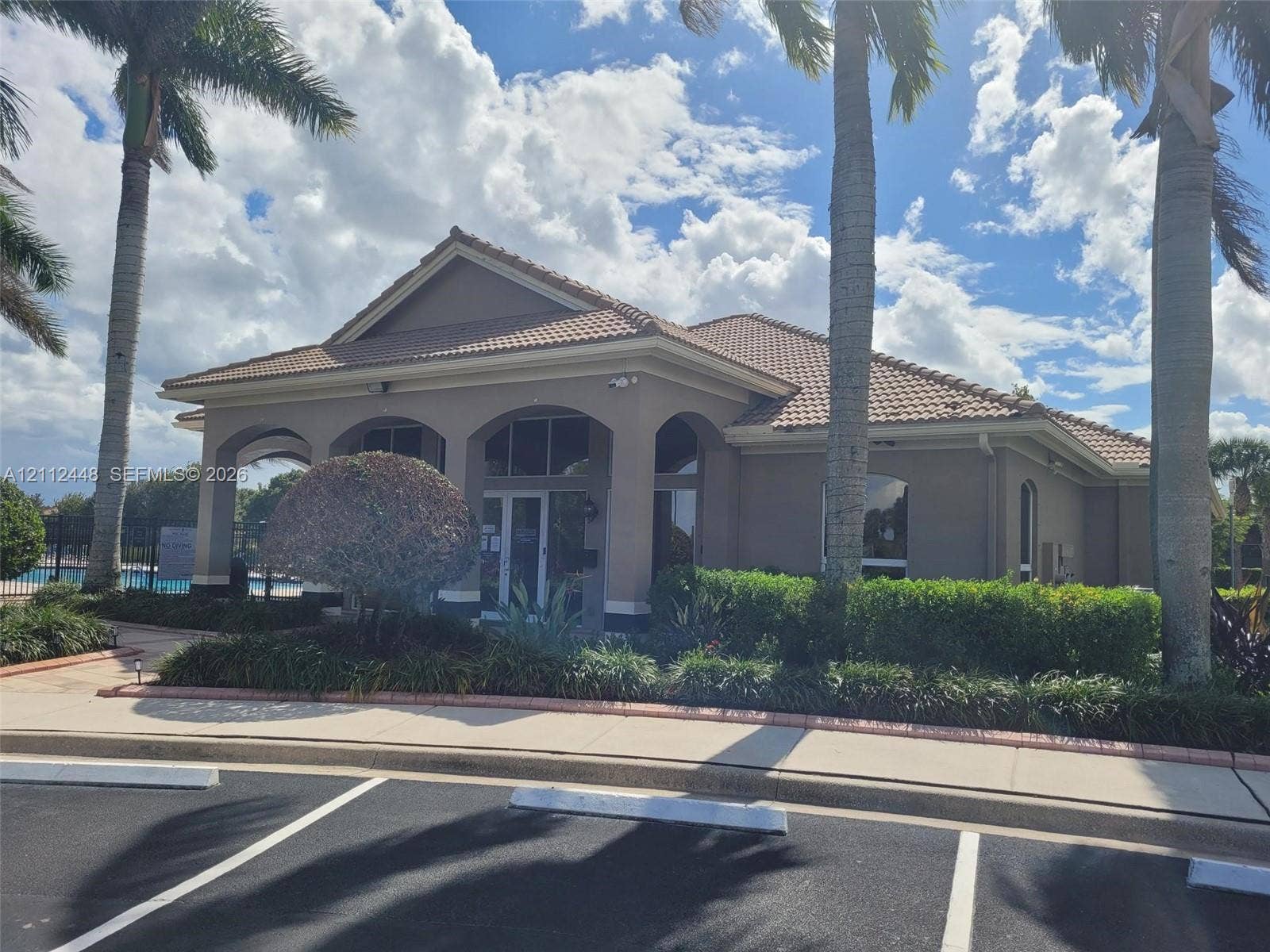 2007 SW Marblehead Way, Port St Lucie, FL 34953 Stucco exterior featuring an arched entryway, tile roof, and landscaped garden beds