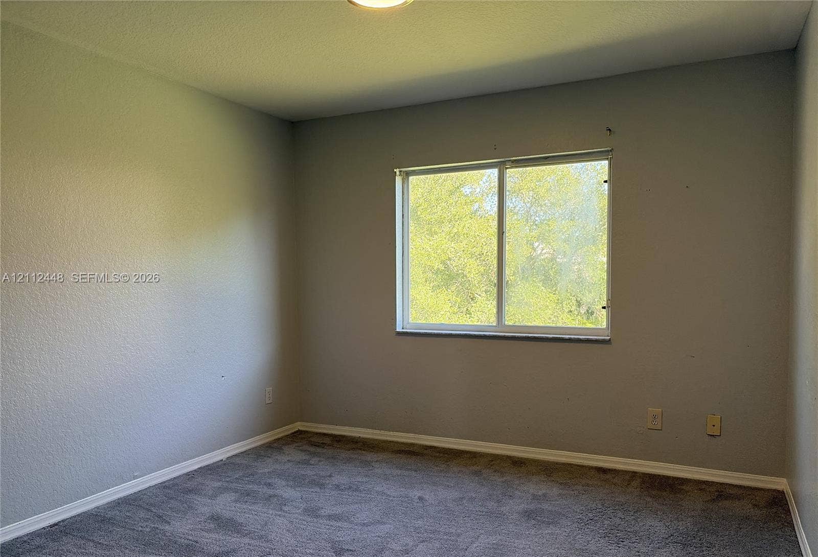 2007 SW Marblehead Way, Port St Lucie, FL 34953 Interior room featuring neutral-toned walls, grey carpeting, and a sliding glass window