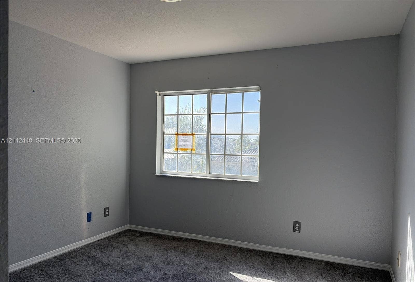 2007 SW Marblehead Way, Port St Lucie, FL 34953 Neutral-toned walls, gray carpeting, and a multi-pane sliding window