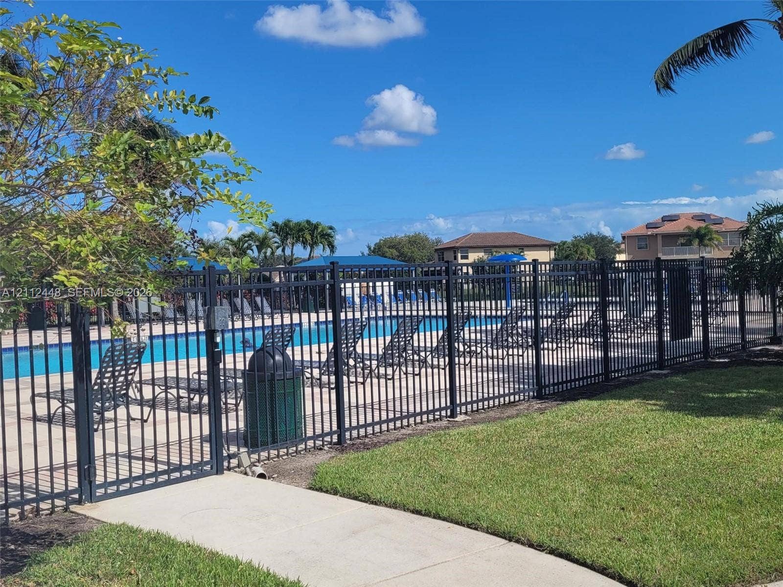 2007 SW Marblehead Way, Port St Lucie, FL 34953 Outdoor swimming pool featuring a concrete deck and black metal perimeter fencing