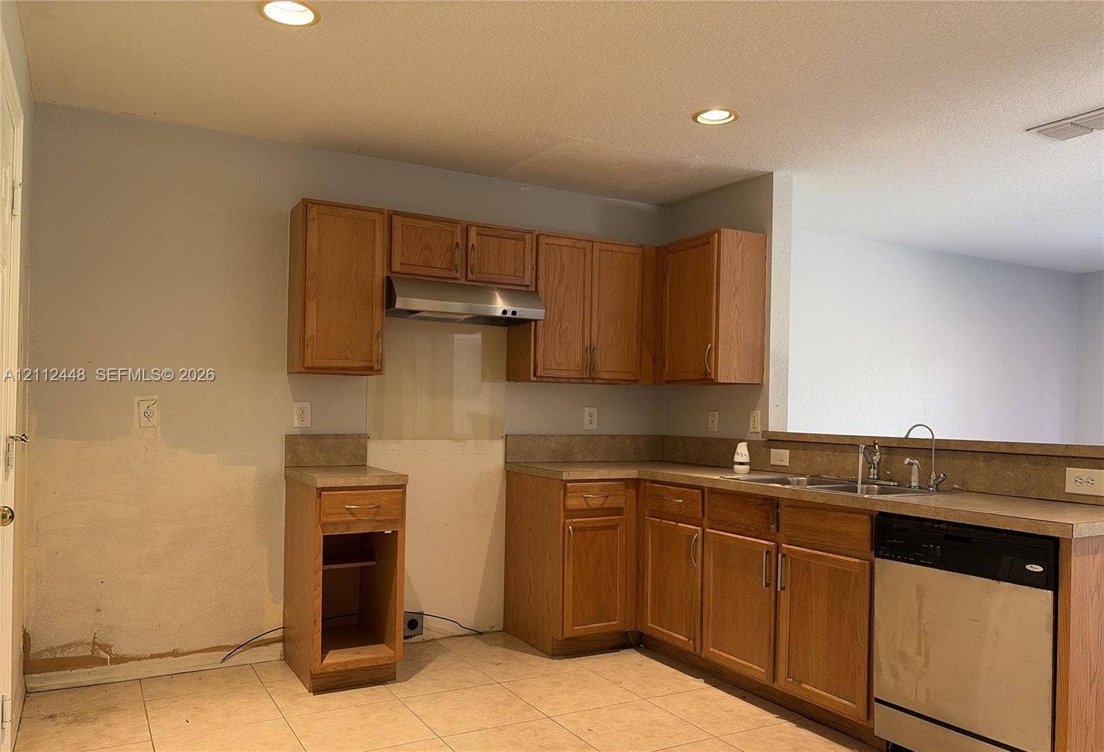 2007 SW Marblehead Way, Port St Lucie, FL 34953 Kitchen featuring wood cabinetry, stainless steel range hood, stainless steel dishwasher, double basin sink, and tile flooring