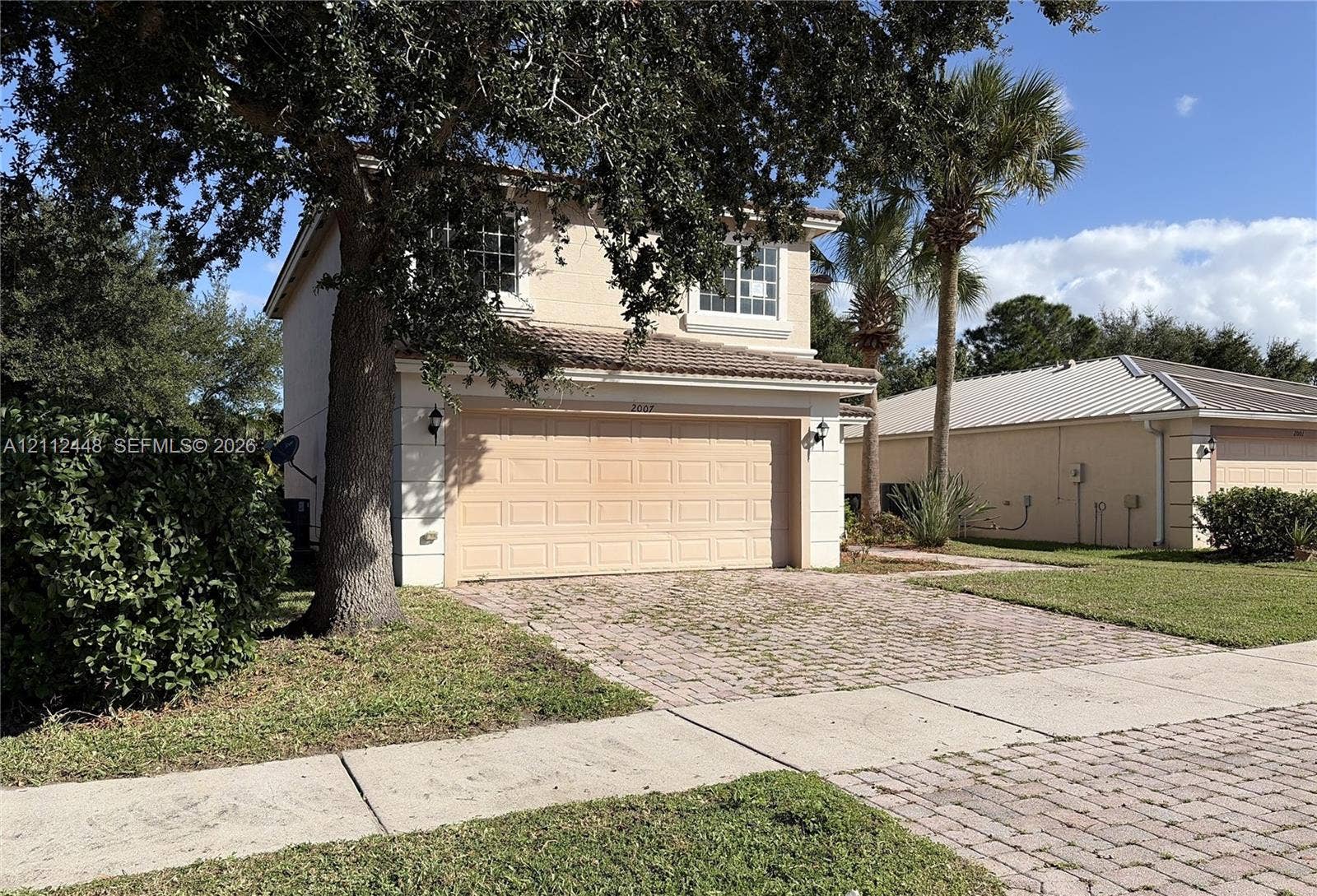 2007 SW Marblehead Way, Port St Lucie, FL 34953 Two-story residence featuring a stucco exterior, concrete tile roof, attached two-car garage, and paver driveway