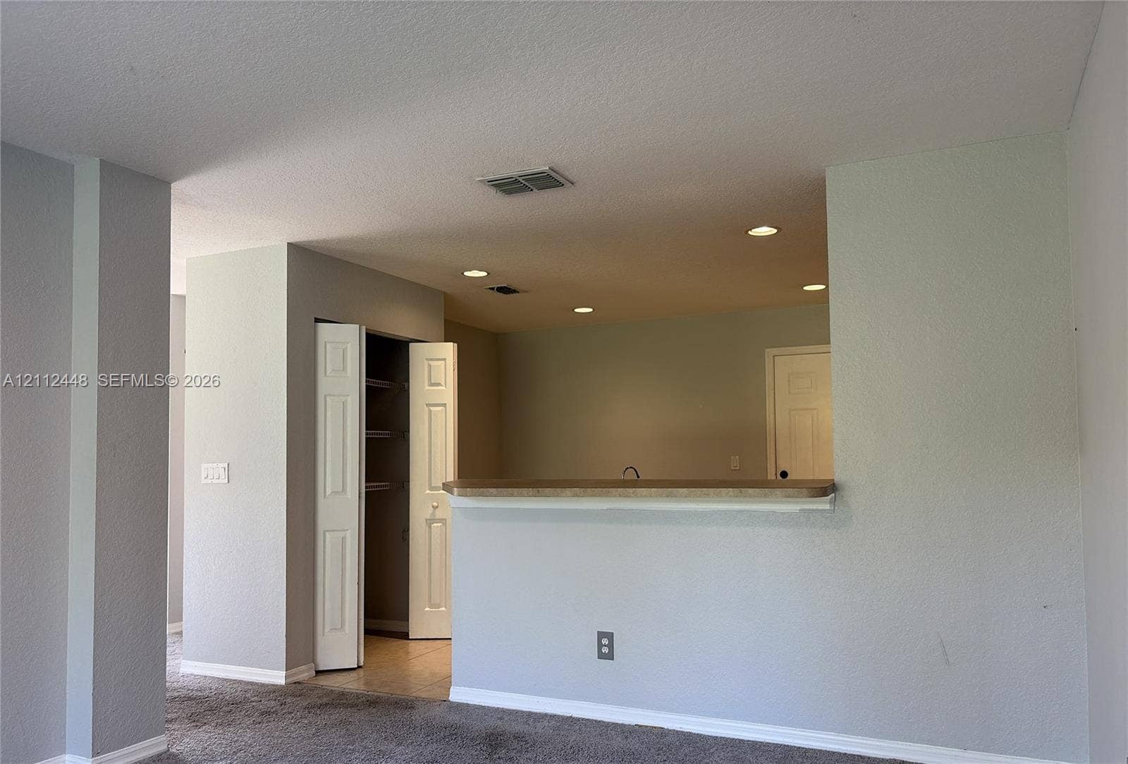 2007 SW Marblehead Way, Port St Lucie, FL 34953 Pass-through breakfast bar with stone-surfaced countertop, recessed ceiling lighting, and built-in closet with shelving