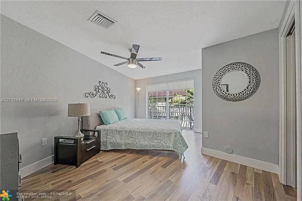 725 SE 14th Court, Fort Lauderdale, FL 33316 Room featuring wood-finish flooring, a ceiling fan with integrated lighting, and glass sliding doors providing exterior exposure