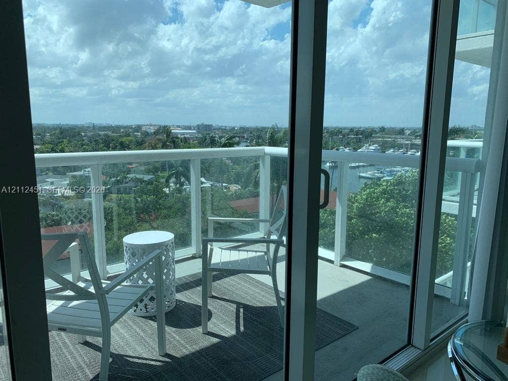 Private balcony featuring floor-to-ceiling glass doors and white metal railings