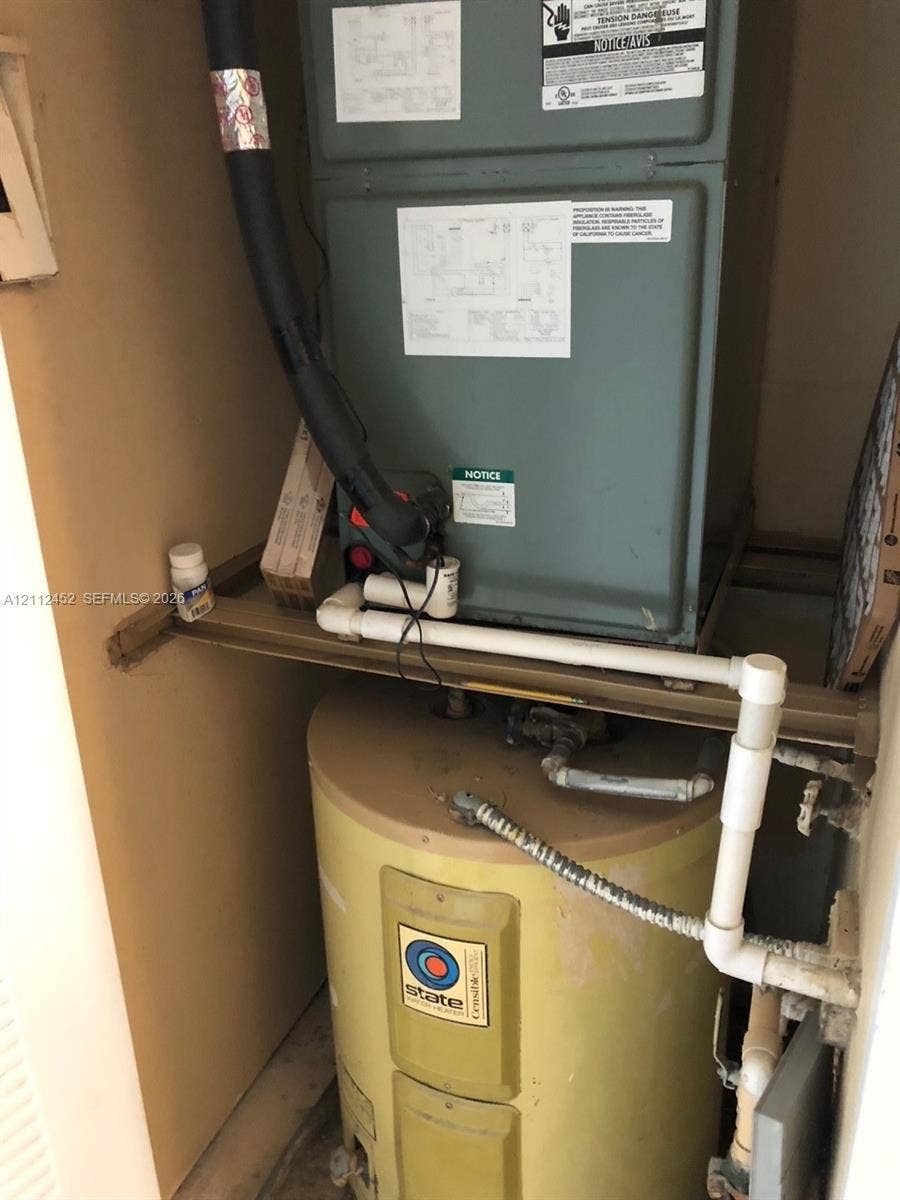 Mechanical closet housing a furnace unit and a cylindrical water heater with PVC plumbing connections