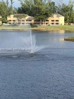 Waterfront setting featuring a central aerating fountain, expansive body of water, and surrounding grassy landscape