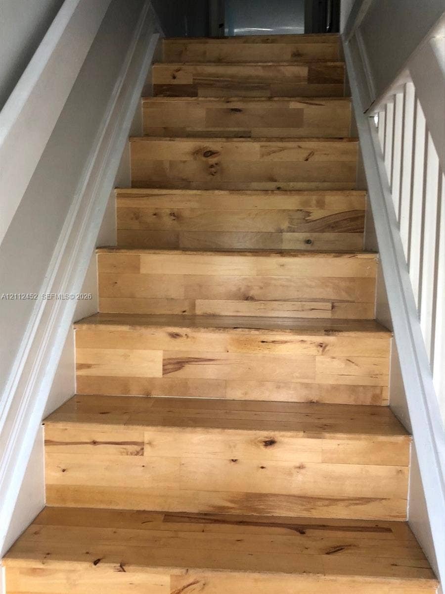 Staircase featuring wood-finish treads and white-painted balustrades