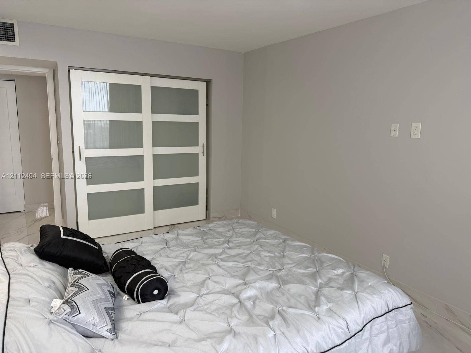 3800 S Ocean Drive, #1601, Hollywood, Hollywood, FL 33019 Sliding closet doors featuring frosted glass panels and white frames, stone-finish flooring, and neutral wall tones