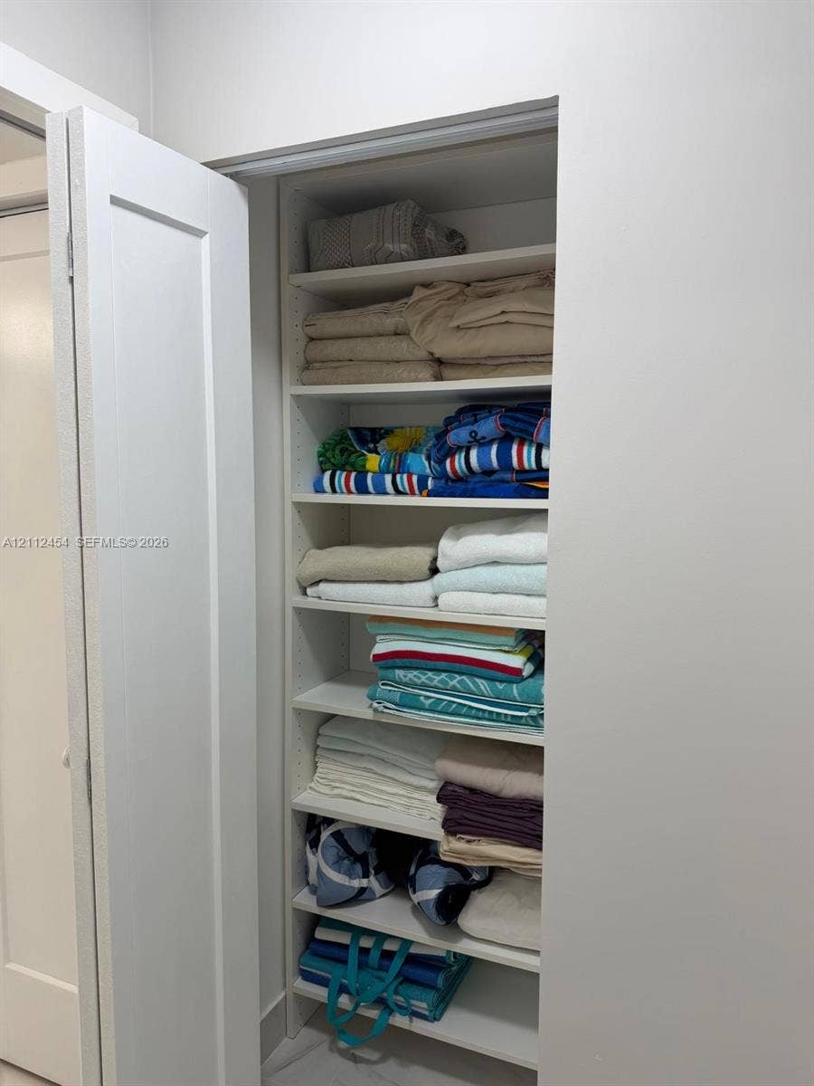 3800 S Ocean Drive, #1601, Hollywood, Hollywood, FL 33019 Built-in recessed shelving unit featuring adjustable white cabinetry and a solid-core swing door