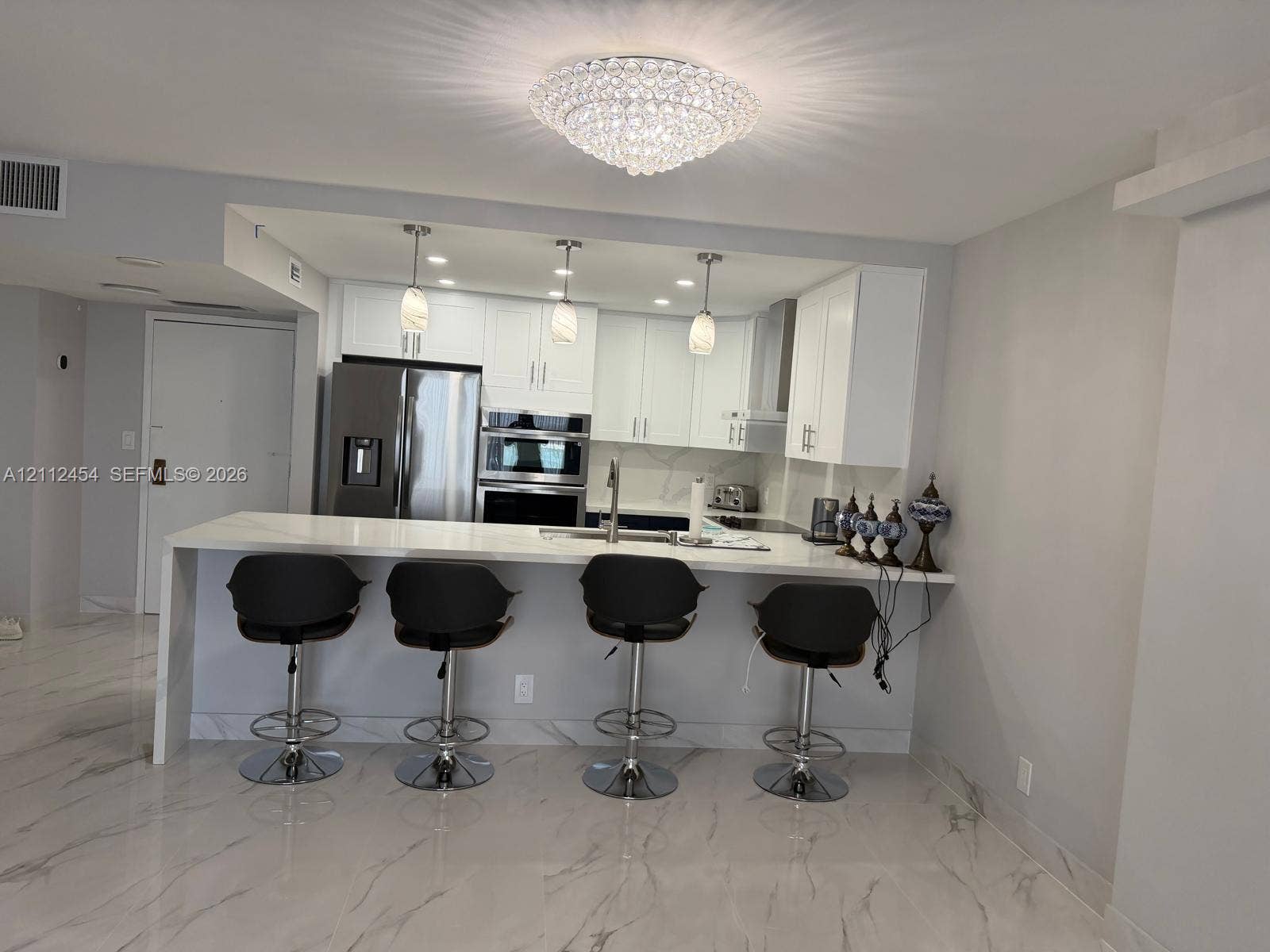 3800 S Ocean Drive, #1601, Hollywood, Hollywood, FL 33019 Kitchen featuring white cabinetry, a waterfall-edge stone countertop, stainless steel built-in double wall oven, pendant lighting, and stone-finish flooring