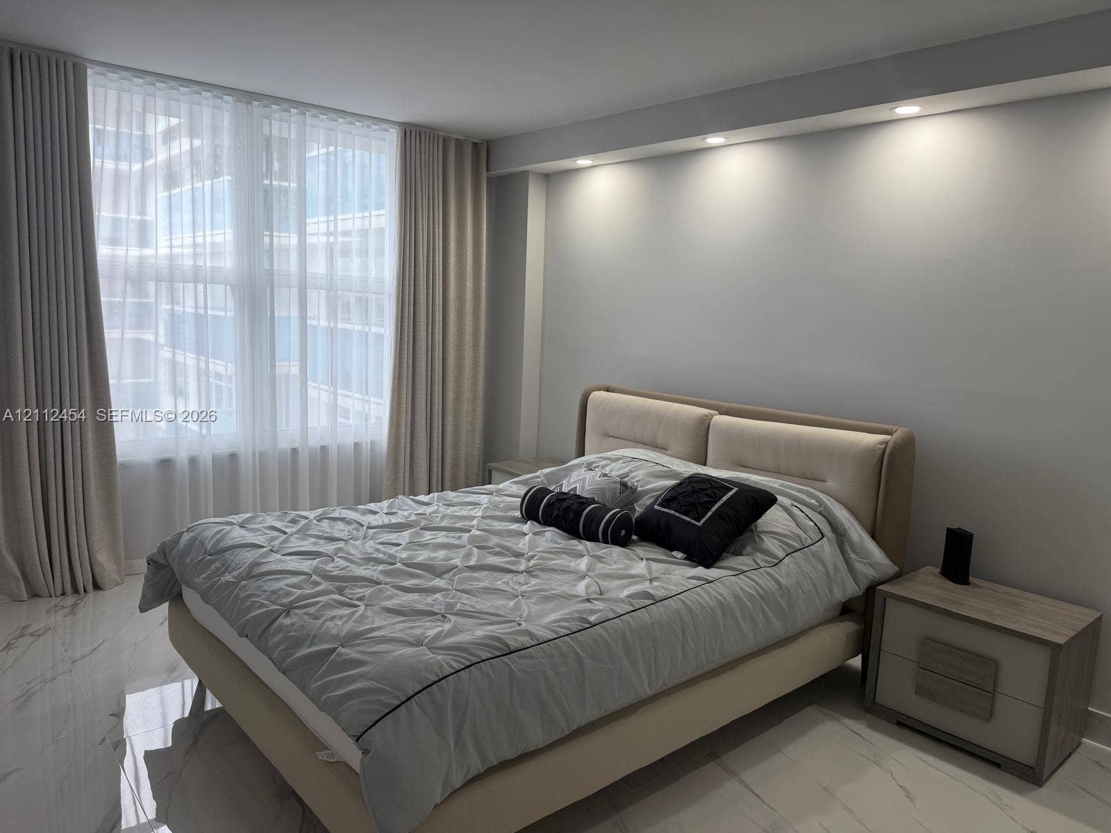 3800 S Ocean Drive, #1601, Hollywood, Hollywood, FL 33019 Floor-to-ceiling windows with floor-length drapery, recessed ceiling lighting, and polished stone-finish flooring