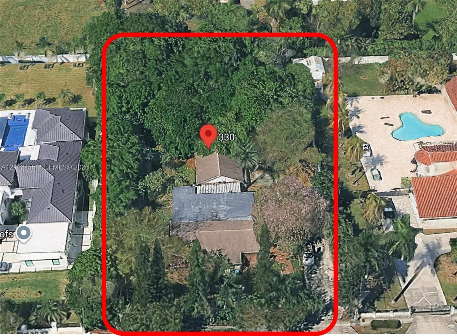 Aerial perspective of property featuring a multi-section roofline, extensive mature tree canopy, and substantial parcel depth