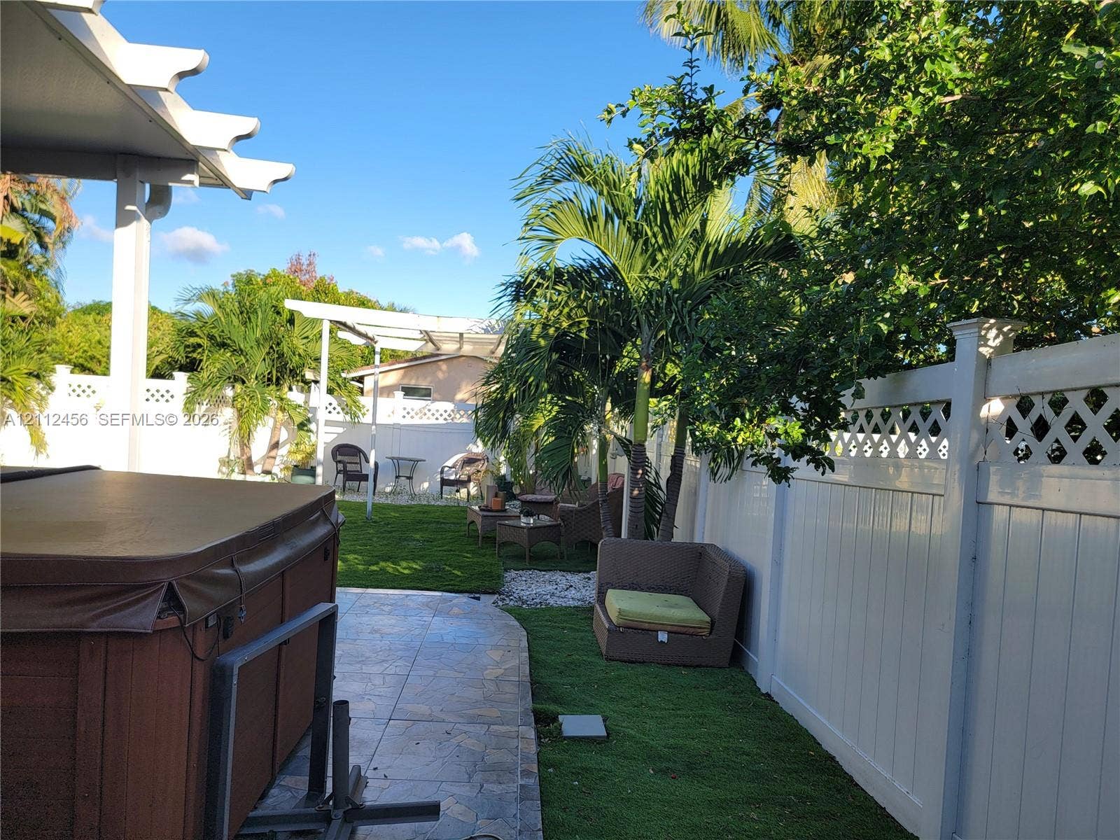 3961 NW 110th Avenue, #3961, Coral Springs, Coral Springs, FL 33065 Backyard featuring a paved patio, covered pergola, vinyl privacy fencing with lattice detail, and established palm trees