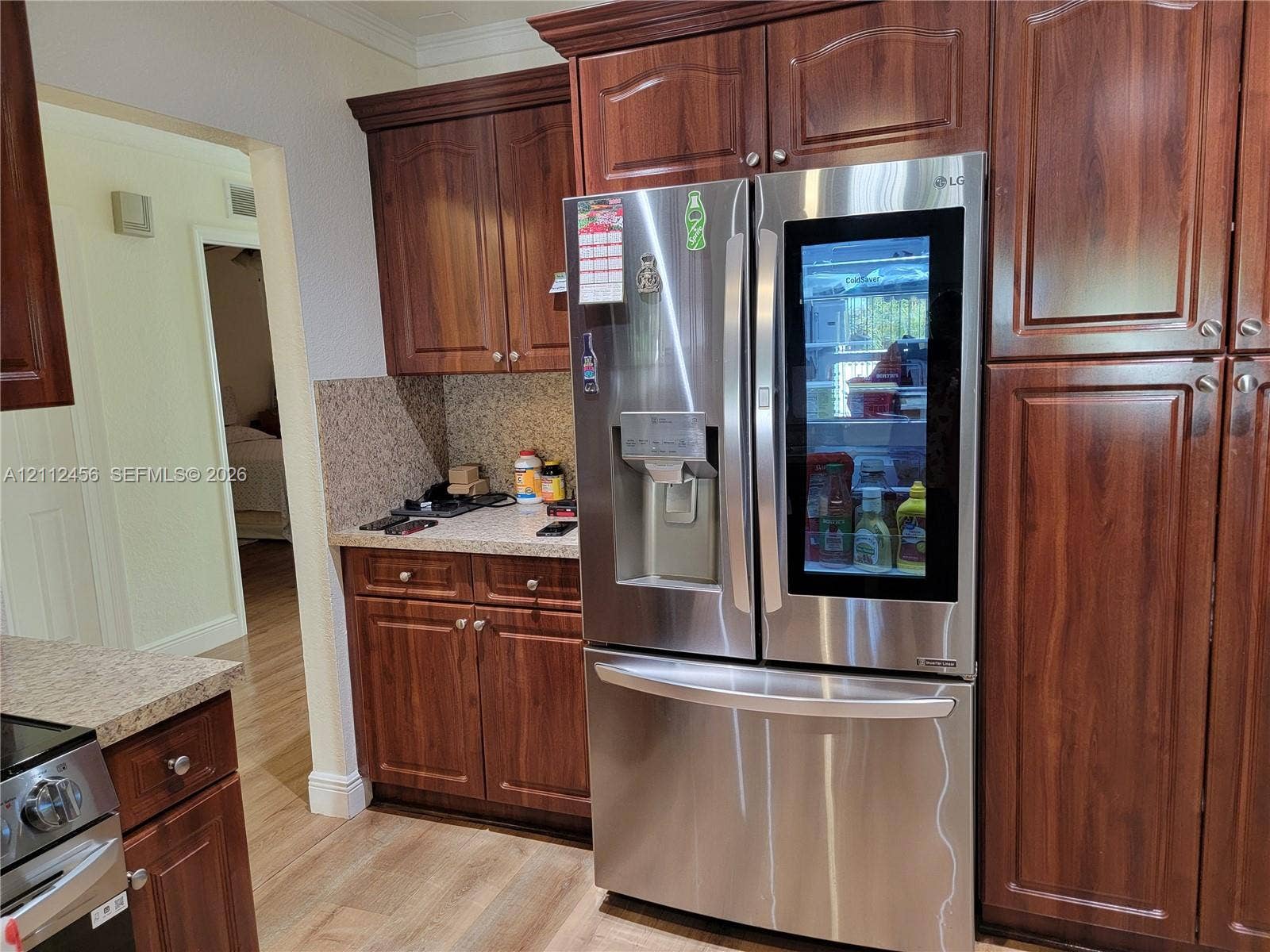 3961 NW 110th Avenue, #3961, Coral Springs, Coral Springs, FL 33065 Stained wood cabinetry, stone-texture countertops, and stainless steel French door refrigerator with glass-panel door