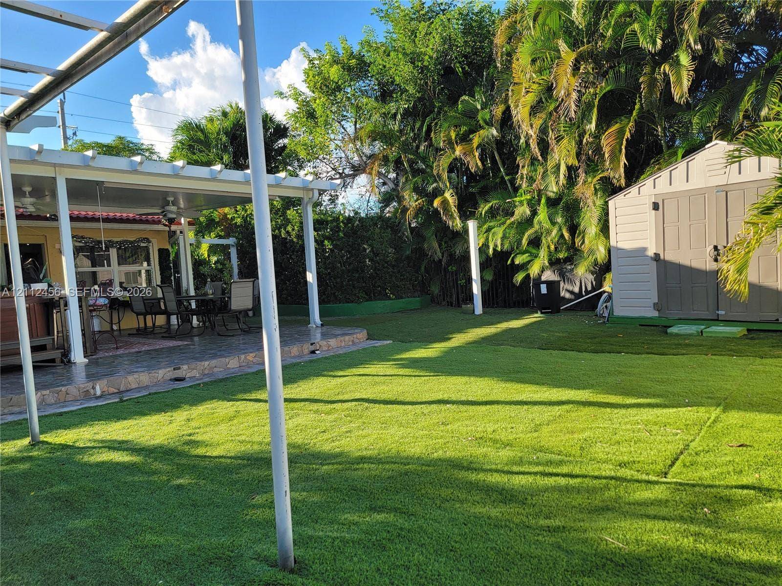 3961 NW 110th Avenue, #3961, Coral Springs, Coral Springs, FL 33065 Rear patio featuring a covered pergola, tiled flooring, artificial turf lawn, and a structural storage shed