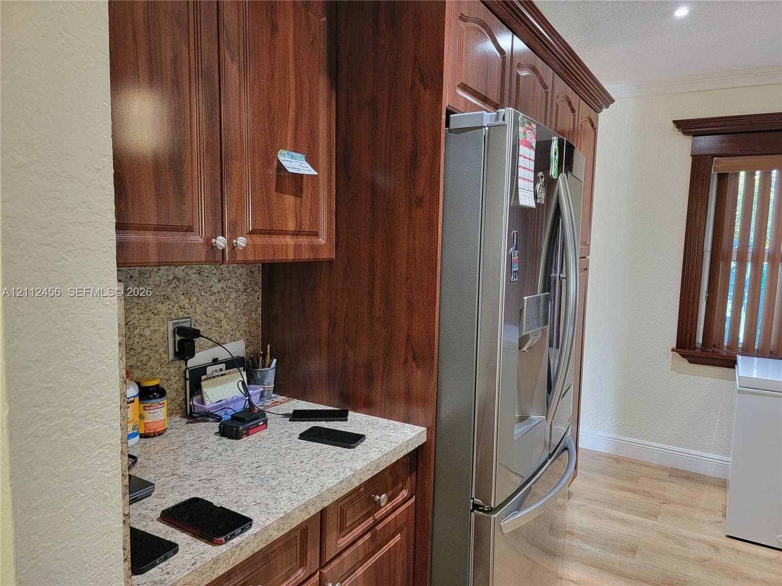 3961 NW 110th Avenue, #3961, Coral Springs, Coral Springs, FL 33065 Kitchen cabinetry featuring dark wood-finish, stone-patterned countertops, a stainless steel refrigerator, and wood-finish flooring