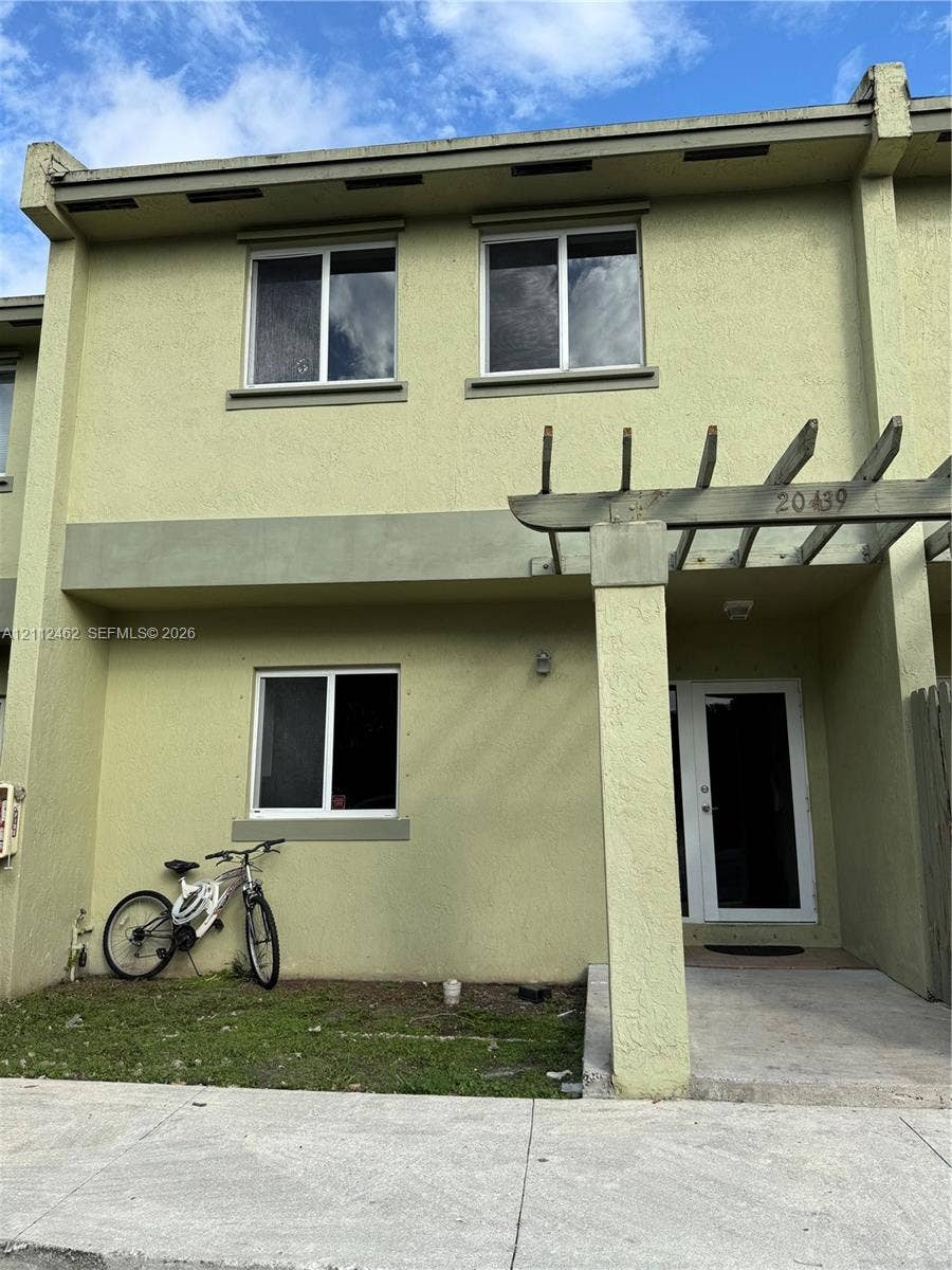 20439 NW 15th Avenue, #9, Miami Gardens, Miami Gardens, FL 33169 Stucco exterior featuring a wood-beam pergola, double-pane windows, and a concrete entry path