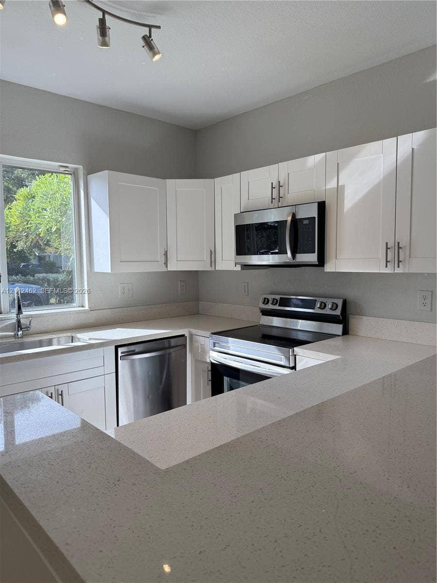 20439 NW 15th Avenue, #9, Miami Gardens, Miami Gardens, FL 33169 Kitchen featuring white shaker-style cabinetry, quartz countertops, stainless steel appliances, and a single-basin undermount sink