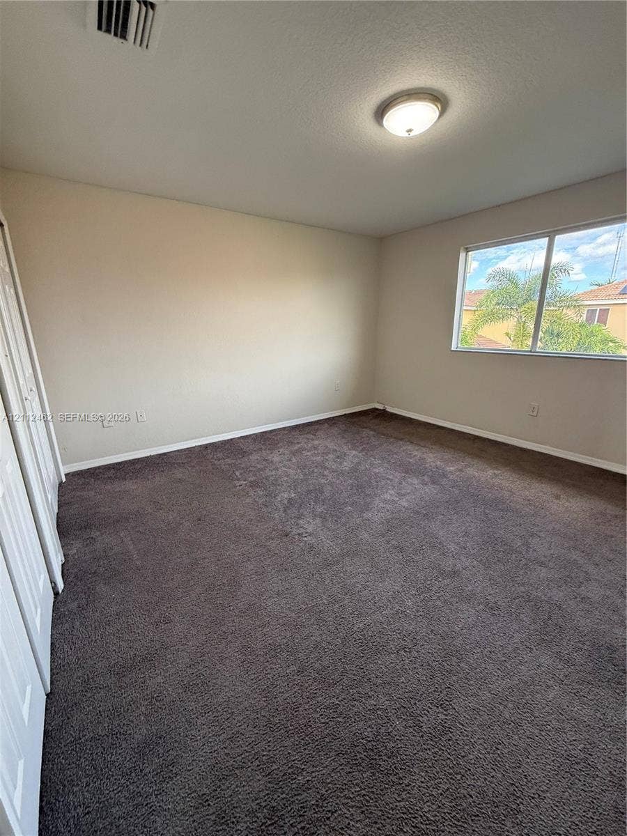 20439 NW 15th Avenue, #9, Miami Gardens, Miami Gardens, FL 33169 Interior space featuring neutral wall tones, wall-to-wall carpeting, a large sliding-door closet, and a single-pane window