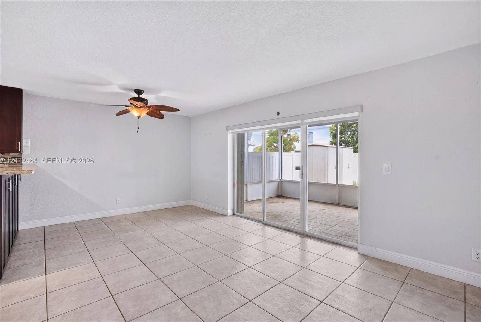 Ceramic tile flooring, sliding glass patio doors, and ceiling fan with integrated lighting