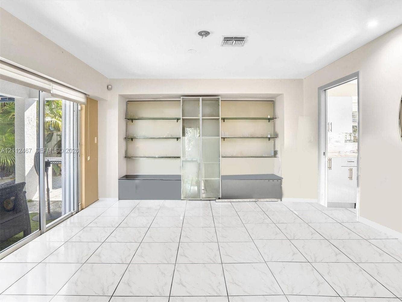 250 NE 212th Street, Miami, Miami, FL 33179 Large-format tile flooring, built-in shelving unit with glass partitions, and full-height sliding glass doors