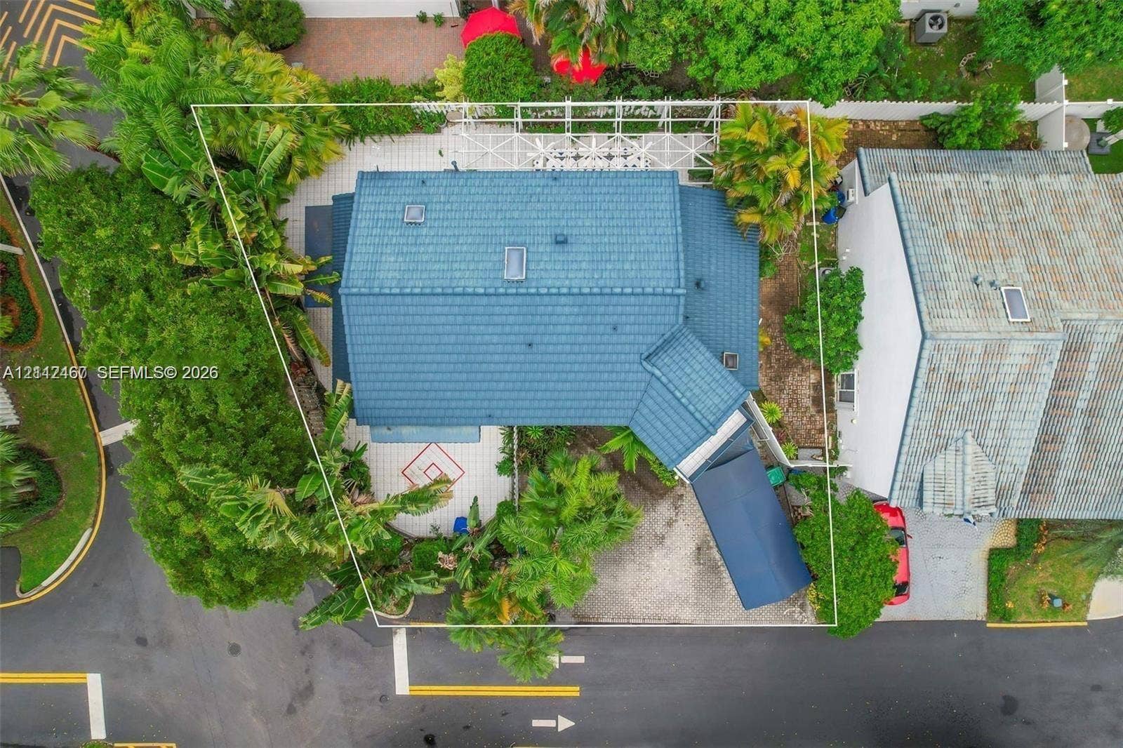 250 NE 212th Street, Miami, Miami, FL 33179 Aerial perspective featuring a tile roof, paved driveway, carport, and landscaped grounds