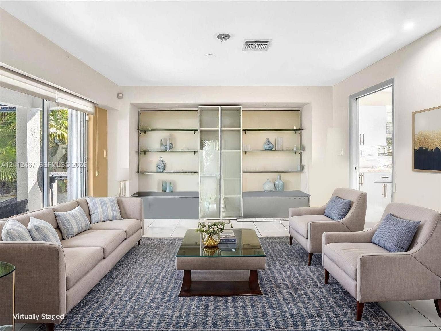 250 NE 212th Street, Miami, Miami, FL 33179 Living space featuring large format tile flooring, built-in recessed display shelving with glass-front cabinetry, and sliding glass doors
