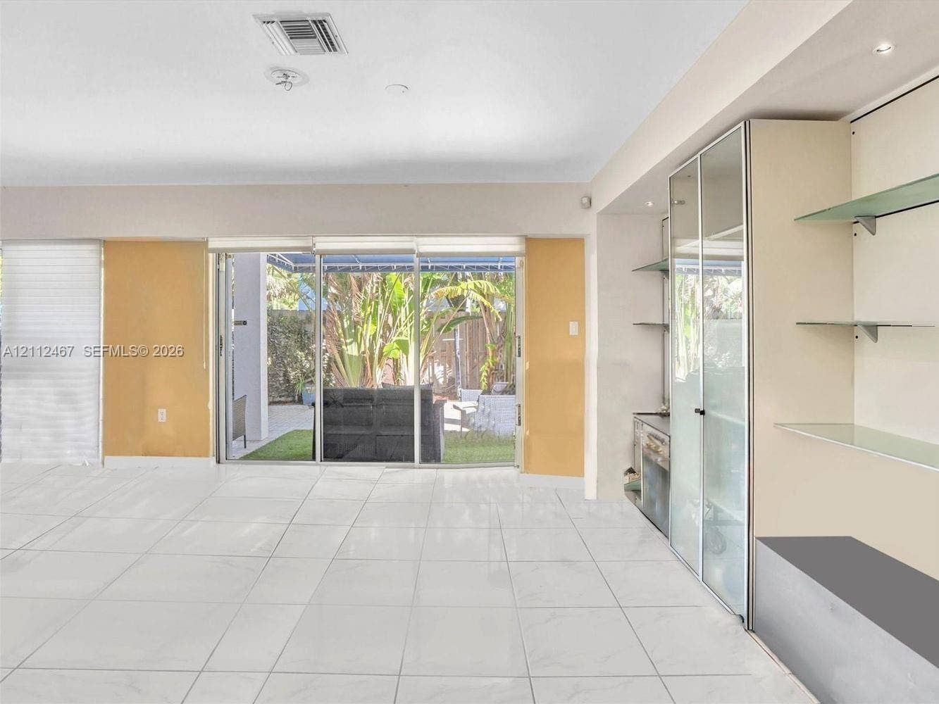 250 NE 212th Street, Miami, Miami, FL 33179 Large-format tile flooring, built-in shelving with glass display cabinets, and floor-to-ceiling sliding glass doors