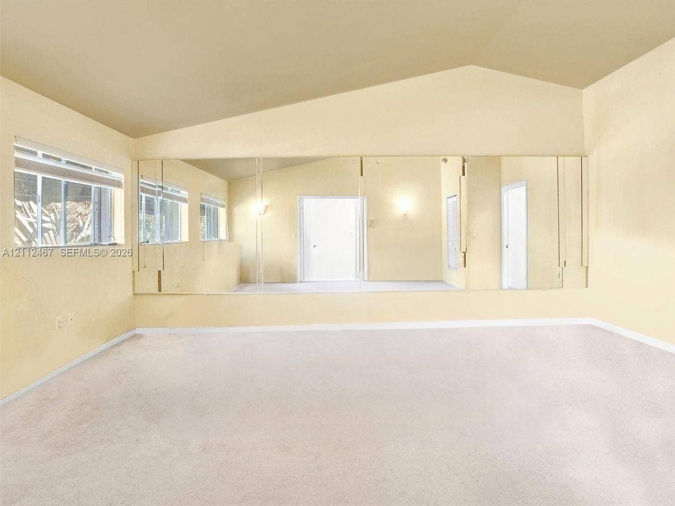 250 NE 212th Street, Miami, Miami, FL 33179 Vaulted ceiling, expansive wall-to-wall mirrored paneling, and carpeted flooring