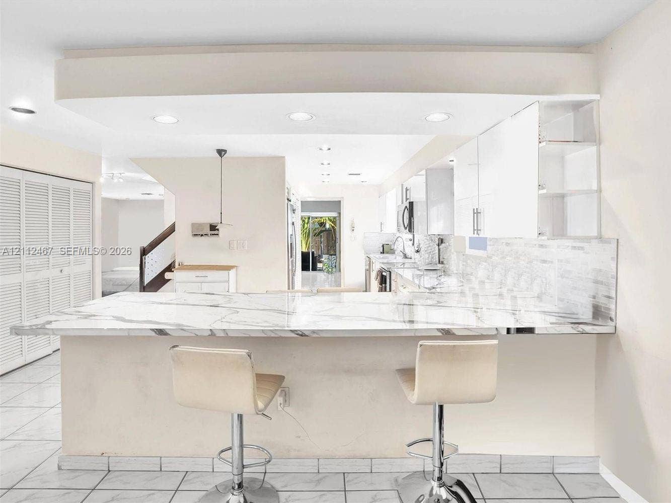 250 NE 212th Street, Miami, Miami, FL 33179 Kitchen featuring a stone-surface breakfast bar, white flat-panel cabinetry, tiled backsplash, recessed lighting, and tile flooring