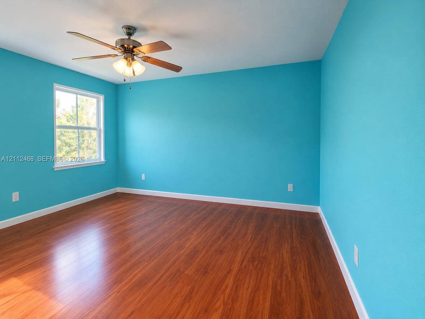 11009 NW 80th Lane, Doral, FL 33178 Room featuring wood-finish flooring, a ceiling fan with integrated lighting, and a single-hung window